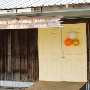 Saddle Tramp Campground front of building and rustic sign