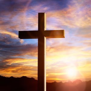 large cross with a colorful sky background