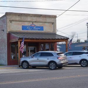 Historic, free-standing brick building with front porch and Le Museé sign