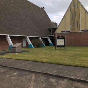 church building with courtyard and sign