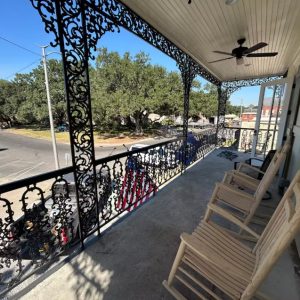 large porch with wrought-iron details and rocking chairs