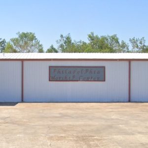 white metal building with red trim and sign that reads, "Philadelphia Worship Center"