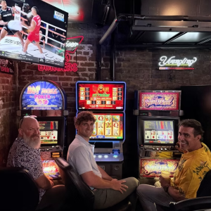 Three men sitting at video poker machines