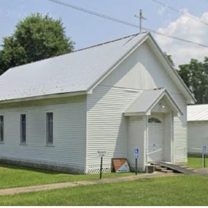 white wood church building with sign to the side